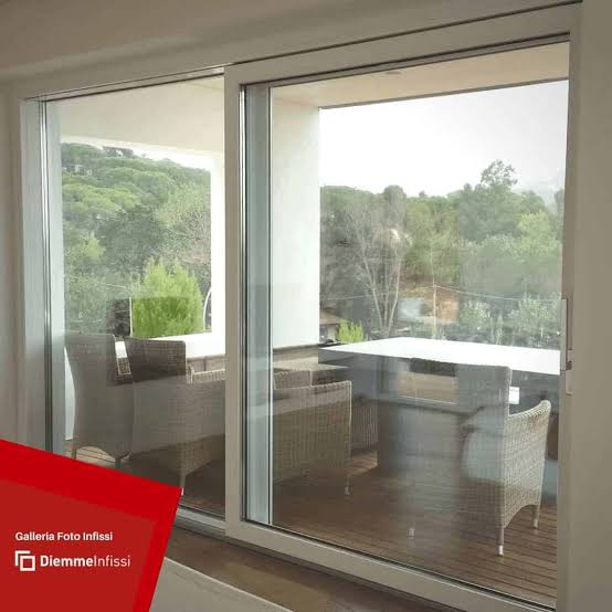 Porta finestra scorrevole alzante con grandi vetrate su soggiorno con vista sul giardino